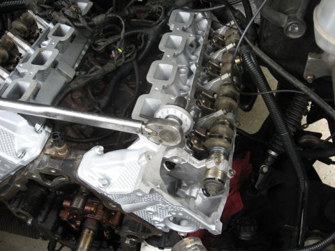 1994 Ford Bronco - Torque wrench being used to tighten valve cover bolts on an engine.