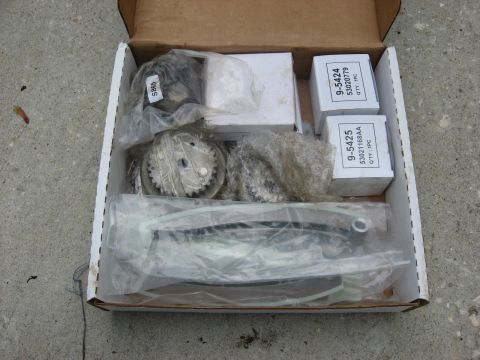 1994 Ford Bronco - Engine timing components are neatly arranged in a cardboard box, ready for installation.