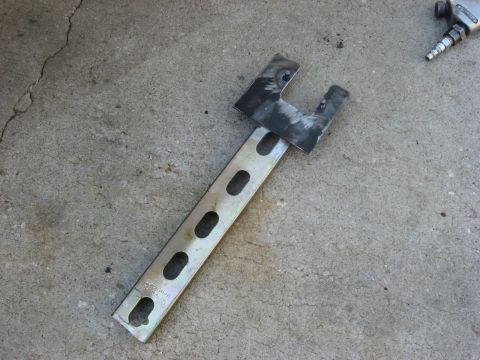1994 Ford Bronco - Custom metal bracket and an air impact wrench are shown on a concrete surface.