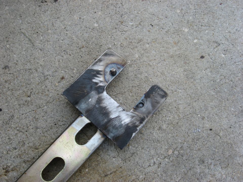 Metal bracket with welds and bolt holes on concrete