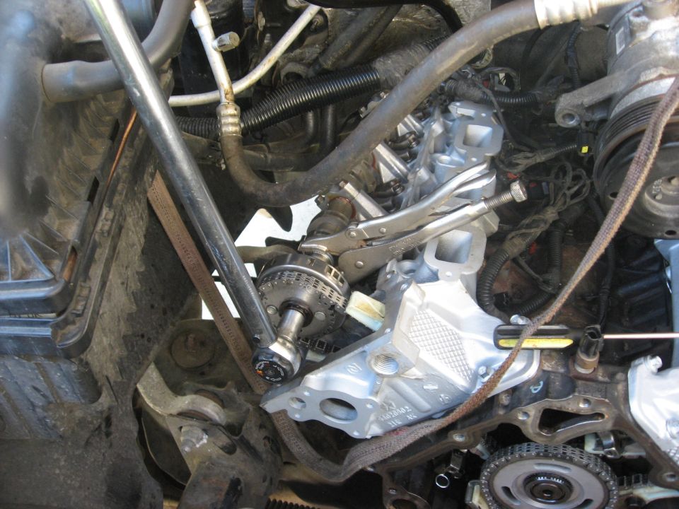 Engine repair in progress, vise grips holding a timing chain component
