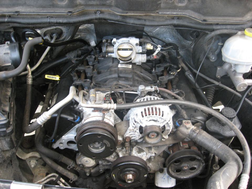 Engine bay with alternator, AC compressor, and throttle body visible
