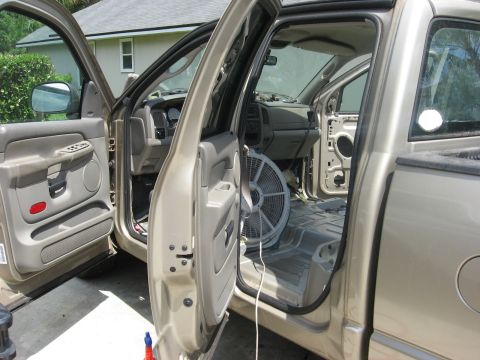 1994 Ford Bronco - The interior of a pickup truck is shown with the doors open and a fan placed on the floor.