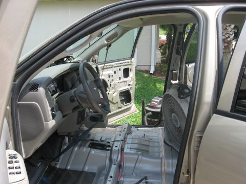 1994 Ford Bronco - The interior of a 2004 Dodge Ram 1500 shows extensive disassembly, with doors off and interior panels removed.