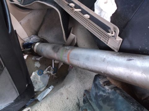 1999 Mercury Grand Marquis - A large metal cylinder lies on the floor of a car's interior amidst debris.