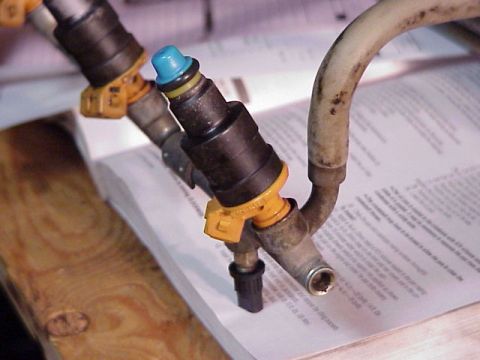 1989 Ford Bronco - Close-up of fuel injectors on a document, showing mechanical parts and text.