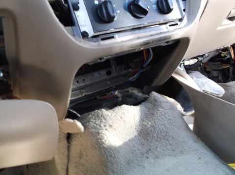 1999 Mercury Grand Marquis - The dashboard of a vehicle is disassembled, revealing exposed wiring and climate control components.
