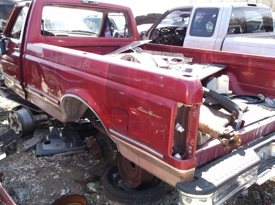 Red pickup truck bed with 'Eddie Bauer' badging, rear view