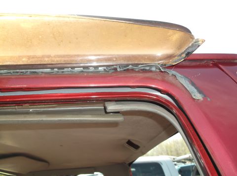 1999 Mercury Grand Marquis - The weather stripping around the roof trim of this vehicle is visibly deteriorated and peeling away.