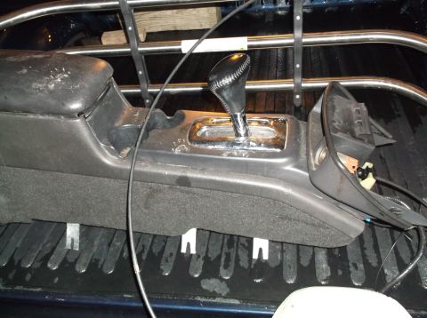 1999 Mercury Grand Marquis - The center console and gear shifter of a 2003 Mercury Grand Marquis are visible, placed in the bed of a truck.