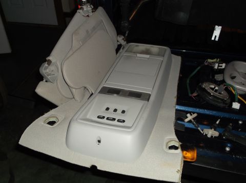 1999 Mercury Grand Marquis - Overhead console and sun visors are shown removed from the interior of a vehicle, revealing exposed wiring and trim panels.