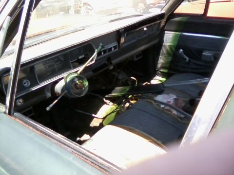 1999 Mercury Grand Marquis - The interior of a car shows a damaged dashboard and worn seats, with visible debris on the floor.