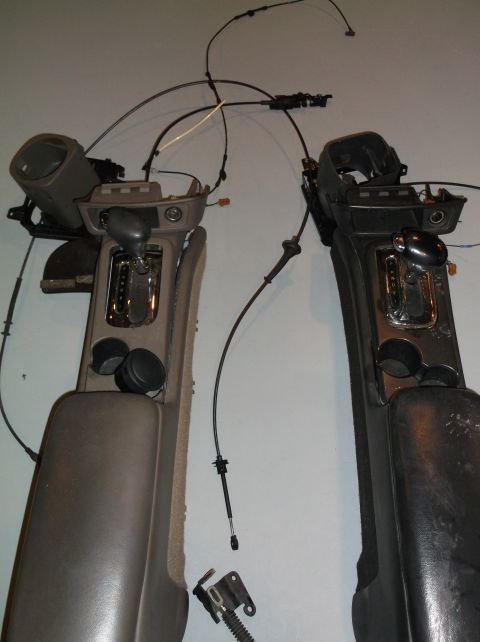 1999 Mercury Grand Marquis - Two automotive center consoles with gear shifters and associated cables are displayed.