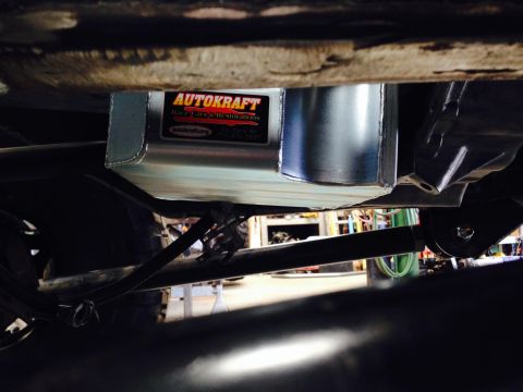 Underside view of a new aluminum oil pan with an AUTOKRAFT label, attached to a vehicle's chassis