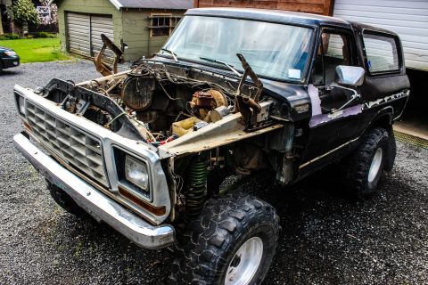1979 Ford Bronco - Front view of a 1979 Ford Bronco undergoing engine work, with the hood and engine removed.