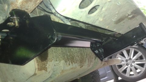 1996 Ford Bronco - A close-up view of the undercarriage of a vehicle, focusing on a newly installed black metal bracket.