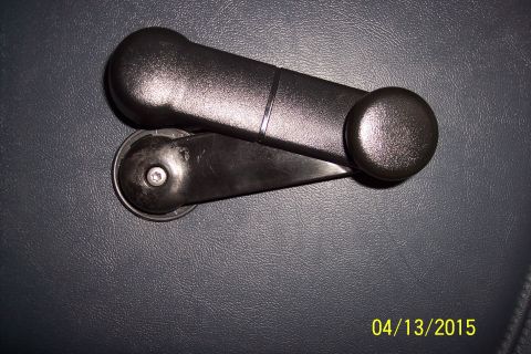 1990 Ford Bronco - A black plastic window crank handle is shown against a dark, textured background.