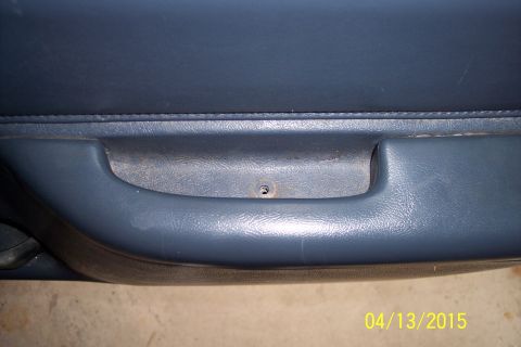 1990 Ford Bronco - Close-up of a blue interior door handle and panel, likely from a vehicle.