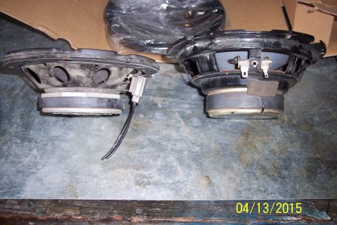 1990 Ford Bronco - Pair of car door speakers shown on a workbench surface.