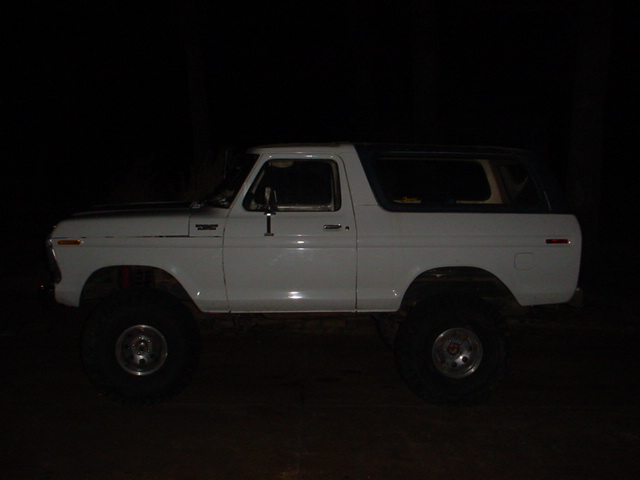 Side view of a white Ford Bronco, lifted with large tires. Looks like a 1978 model