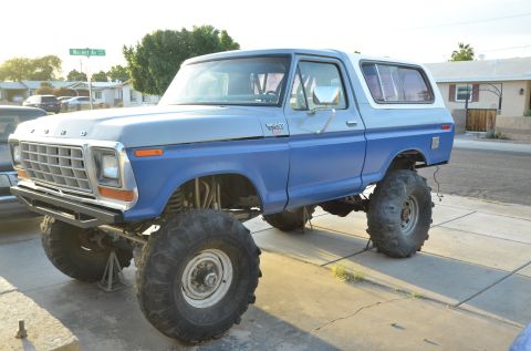 1979 Ford Bronco - This lifted Ford Bronco is parked on a driveway with a street sign in the background.