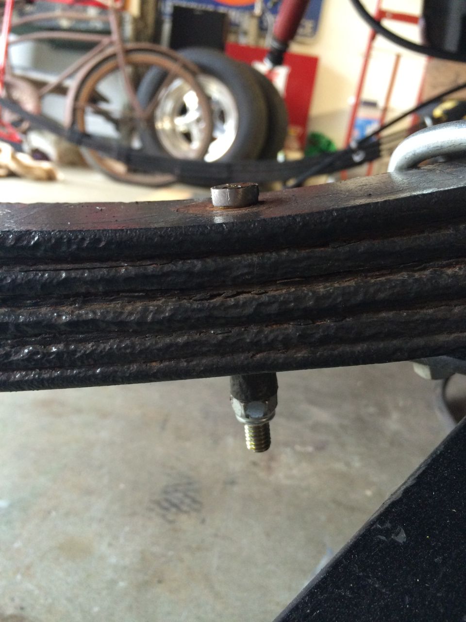 Leaf spring assembly with bolt and nut, showing multiple layers of metal