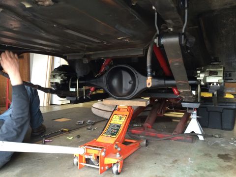 1964 Ford Fairlane - Close-up view of a vehicle's rear axle and suspension system during maintenance.