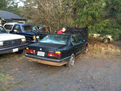 1988 BMW 7 Series - A black 1988 BMW 7 Series sedan sits with its hood open, parked next to other vehicles.
