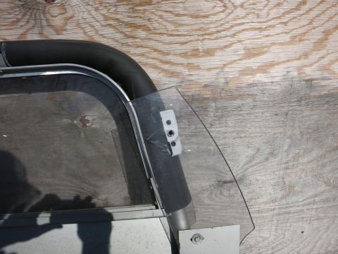 1991 Ford LTD Crown Victoria - Close-up of a car door window frame and glass, detached from a vehicle.