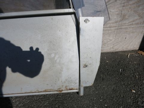 1991 Ford LTD Crown Victoria - A close-up view of a metallic panel shows signs of wear and tear, including rust and a visible rivet securing it.