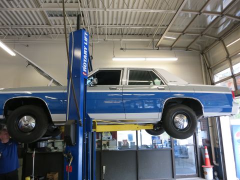 1991 Ford LTD Crown Victoria - A two-tone blue and silver 1991 Ford Crown Victoria LTD is shown on a car lift in a service bay.