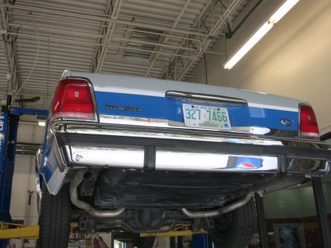 1991 Ford LTD Crown Victoria - The rear of a blue and white Ford Crown Victoria is shown while elevated on a service lift.