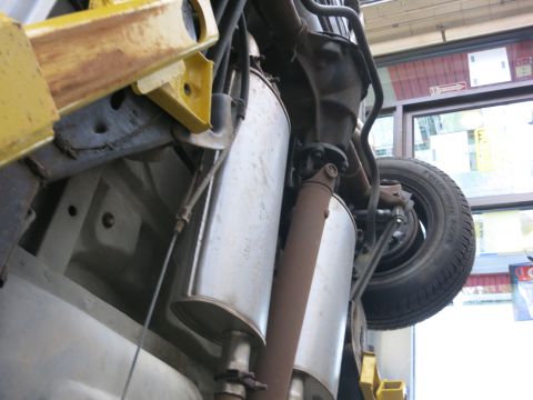 1991 Ford LTD Crown Victoria - The rear undercarriage of a 1991 Ford Crown Victoria LTD is visible, including its dual exhaust system and a tire.