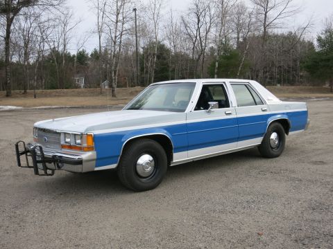 1991 Ford LTD Crown Victoria - This 1991 Ford Crown Victoria LTD police car is parked outdoors on a gravel lot.