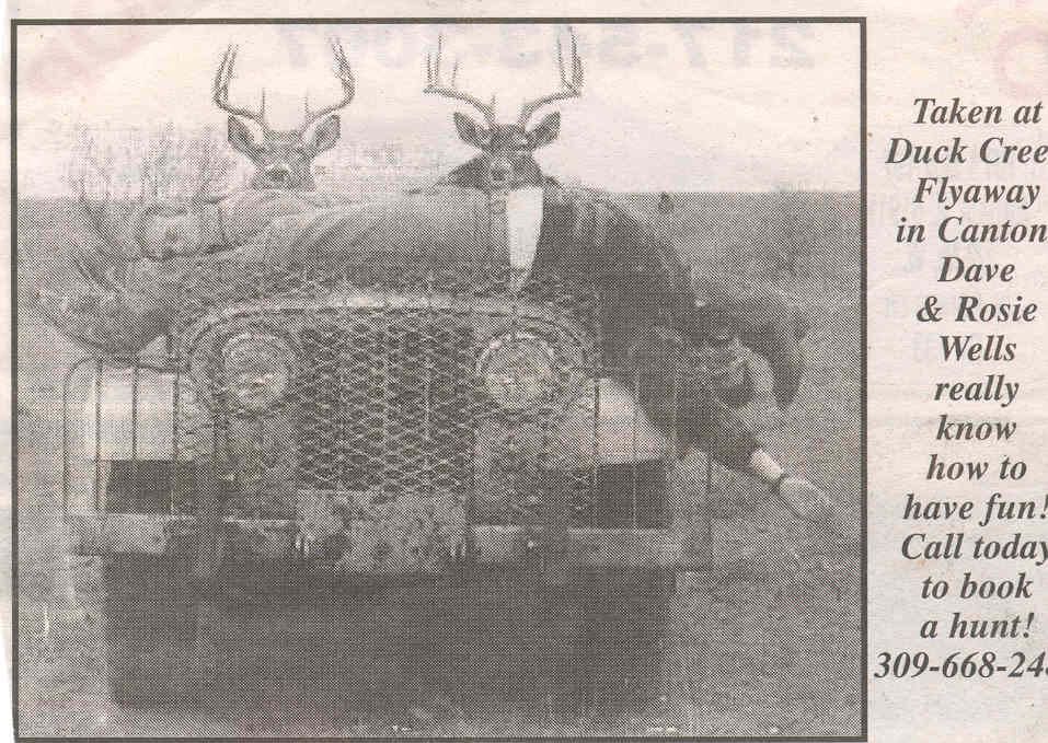 Front view of a weathered Jeep CJ-series with a mesh grille and brush guard, two deer heads mounted on the hood
