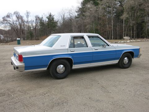 1991 Ford LTD Crown Victoria - Sedan with two-tone paint parked outdoors on a gravel surface.