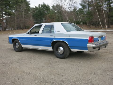 1991 Ford LTD Crown Victoria - This 1991 Ford Crown Victoria LTD is shown from a three-quarter front perspective, a distinctive two-tone blue and white paint scheme.