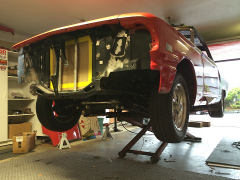 1964 Ford Fairlane - Car body on lift with front end disassembled for repair or restoration.