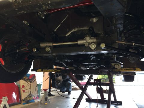 1964 Ford Fairlane - The underside of a vehicle is visible, with focus on the steering mechanism and suspension parts.