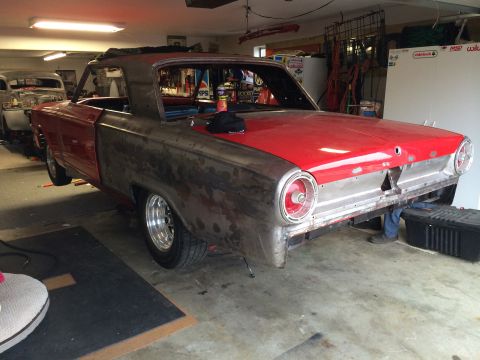 1964 Ford Fairlane - A 1964 Ford Fairlane is shown in a garage, partially restored with exposed metal panels and a red top.