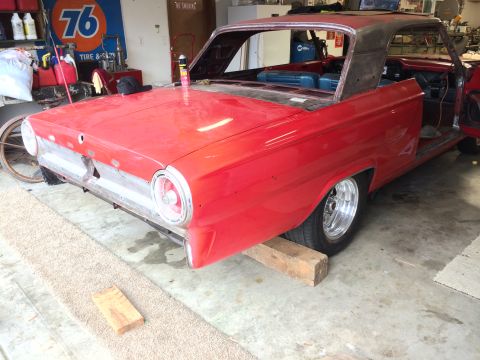 1964 Ford Fairlane - A red 1964 Ford Fairlane coupe is seen from the rear, in a garage setting, with parts of its body removed for restoration.
