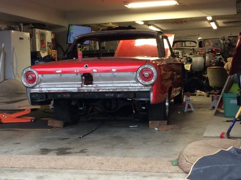 1964 Ford Fairlane - Rear view of a 1964 Ford Fairlane coupe being worked on in a garage. Another vehicle is parked behind it.