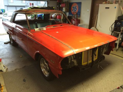 1964 Ford Fairlane - A red 1964 Ford Fairlane convertible is parked in a garage, showing signs of restoration work.