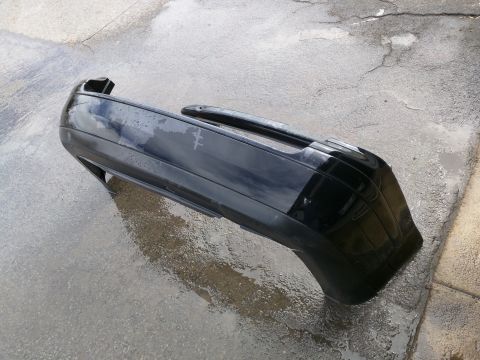 2002 Volkswagen Jetta - A black bumper is shown lying on a wet concrete surface.
