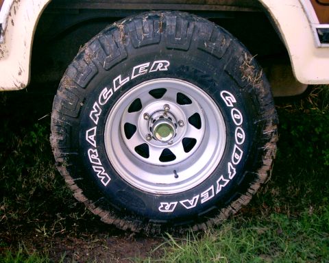 1980 Ford Bronco - A close-up view of a Goodyear Wrangler tire mounted on a vehicle's wheel.