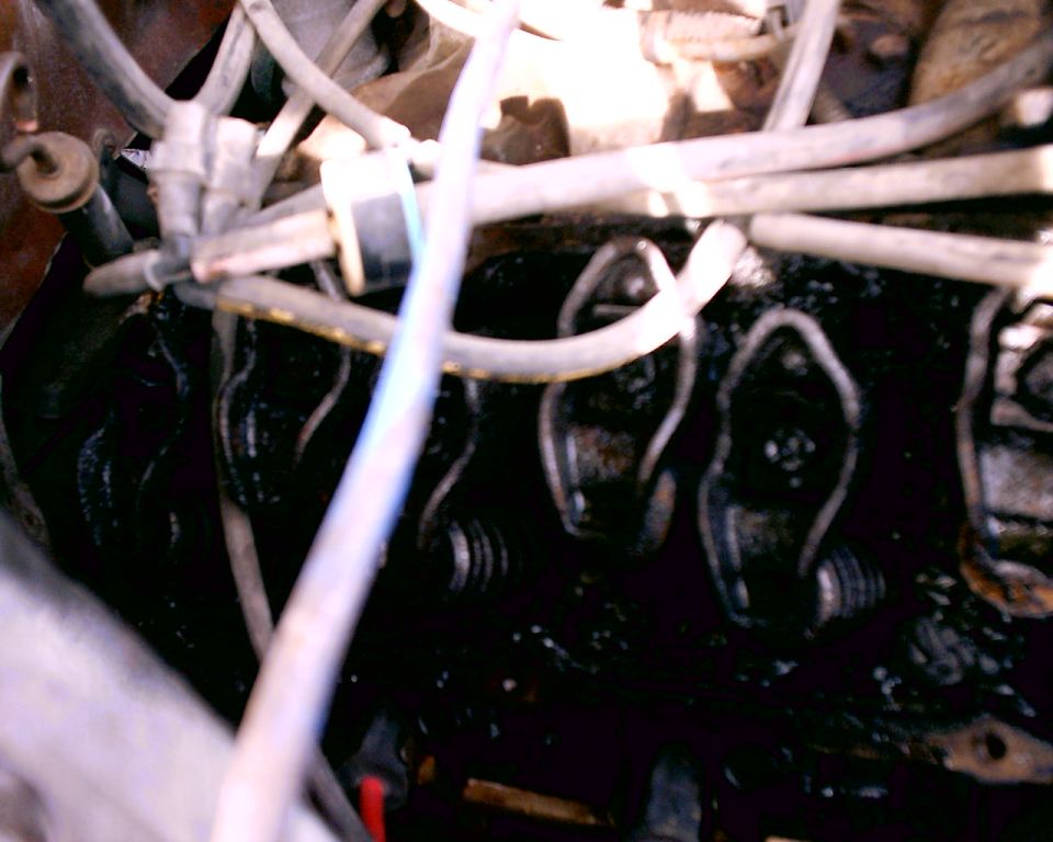 Engine valve train with oil residue and hoses. Supermotors.net logo visible