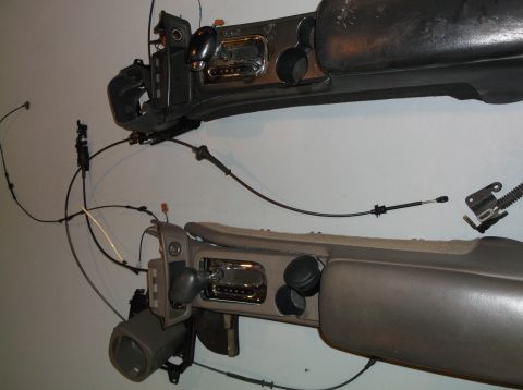 1999 Mercury Grand Marquis - Two disassembled car center consoles, each a gear shifter and various controls, are shown against a plain background.