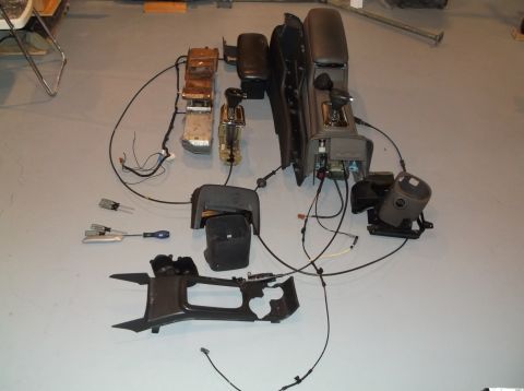 1999 Mercury Grand Marquis - Various disassembled car interior parts are laid out on a floor, including console and shifter components.