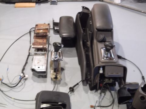 1999 Mercury Grand Marquis - Disassembled car interior console parts are laid out on a floor.