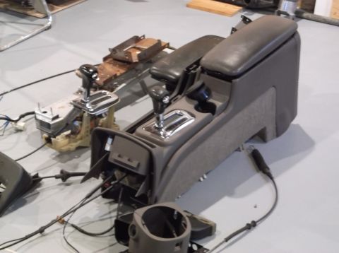 1999 Mercury Grand Marquis - Disassembled car center console and shifter assembly, with additional components visible.